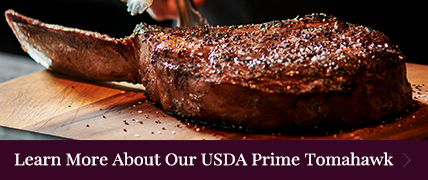 tomahawk steak with words Learn More About Our USDA Prime Tomahawk and an arrow that insinuates to click to go to our story about the tomahawk ribeye - click to learn more